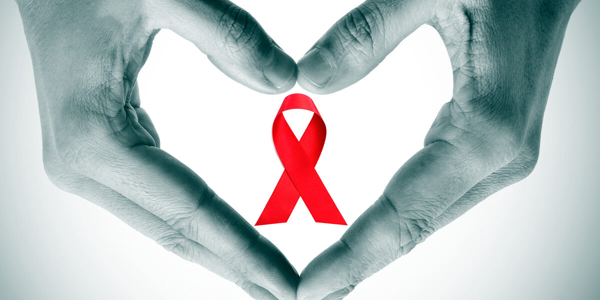 Aids Walk 2019 hands forming a heart with the red ribbon in the middle of the heart representing AIDS awareness