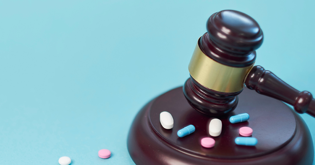 Elmiron Lawsuit Claims Vision Loss featured image showing a gavel slamming on top of multi colored drugs in the form of pills