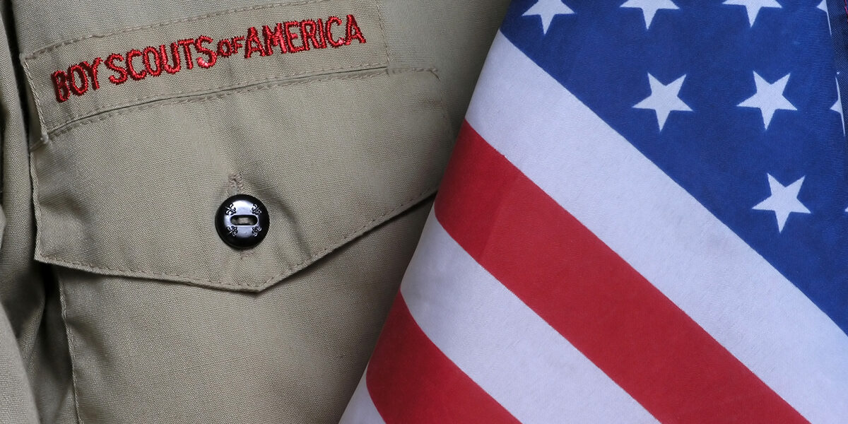Boy Scouts of America tan uniform on the left and American flag on the right