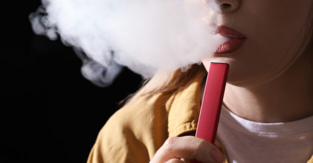 red Juul E-Cigarette being smoked by girl with red lipstick