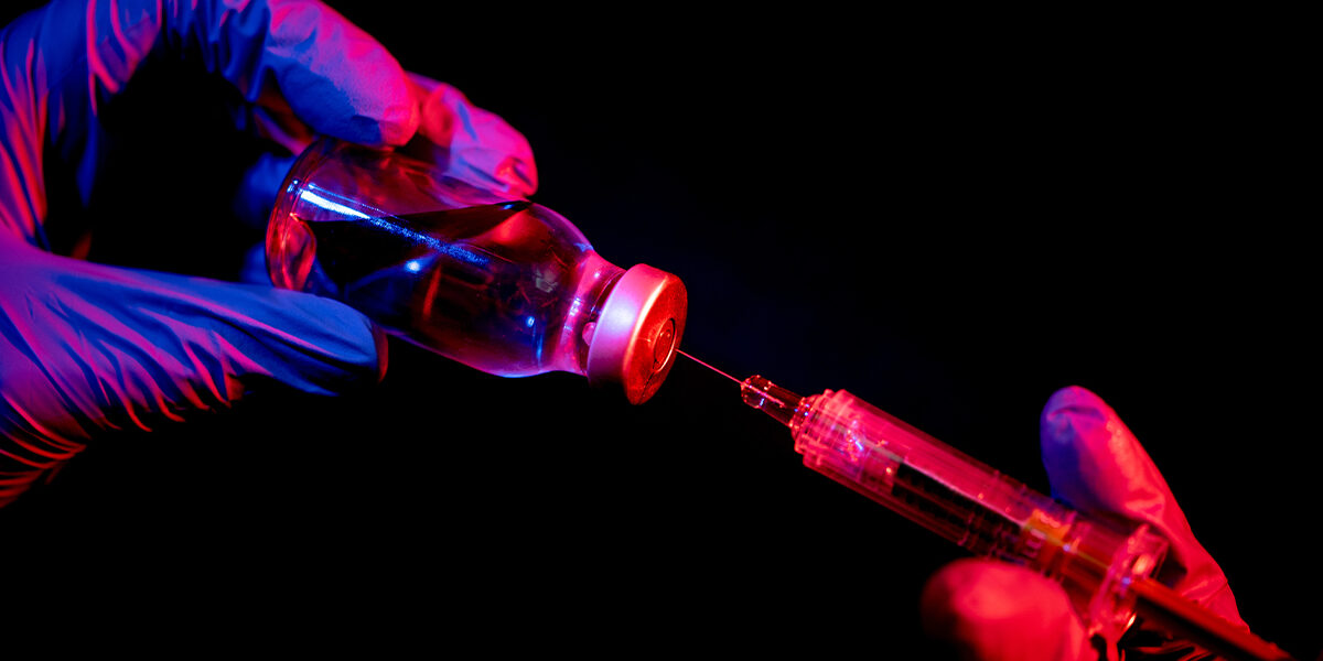 Vaccine Injuries and Adverse Reactions medical doctor drawing liquid medicine out of vial with a syringe